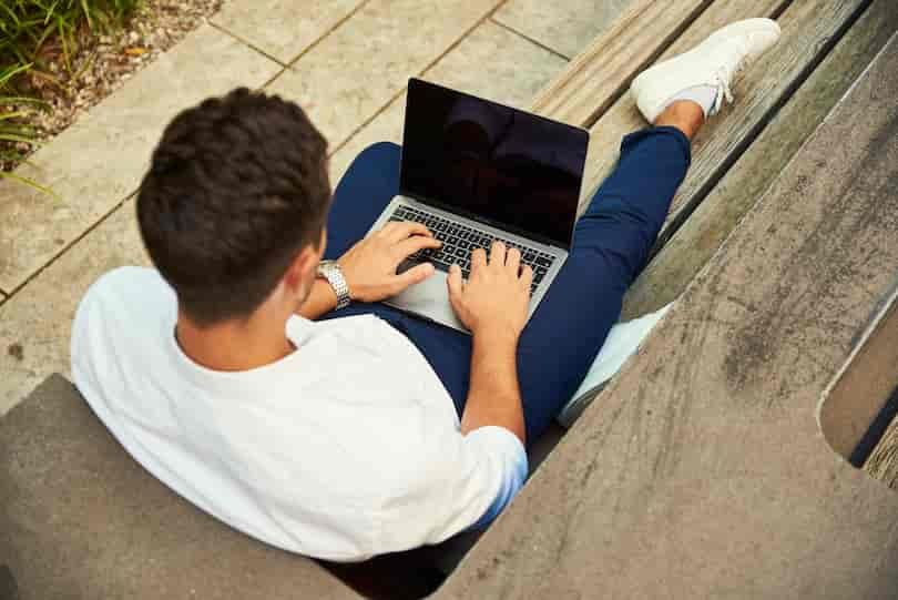 ラフな服装でＰＣを操作する男性の画像