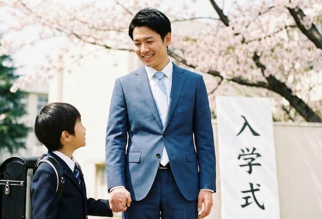爽やかなスーツで入学式に参加する父親