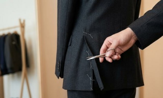 スーツの仕付け糸を切る様子